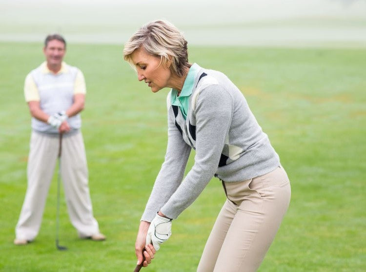 Golfer preparing to putt on a green