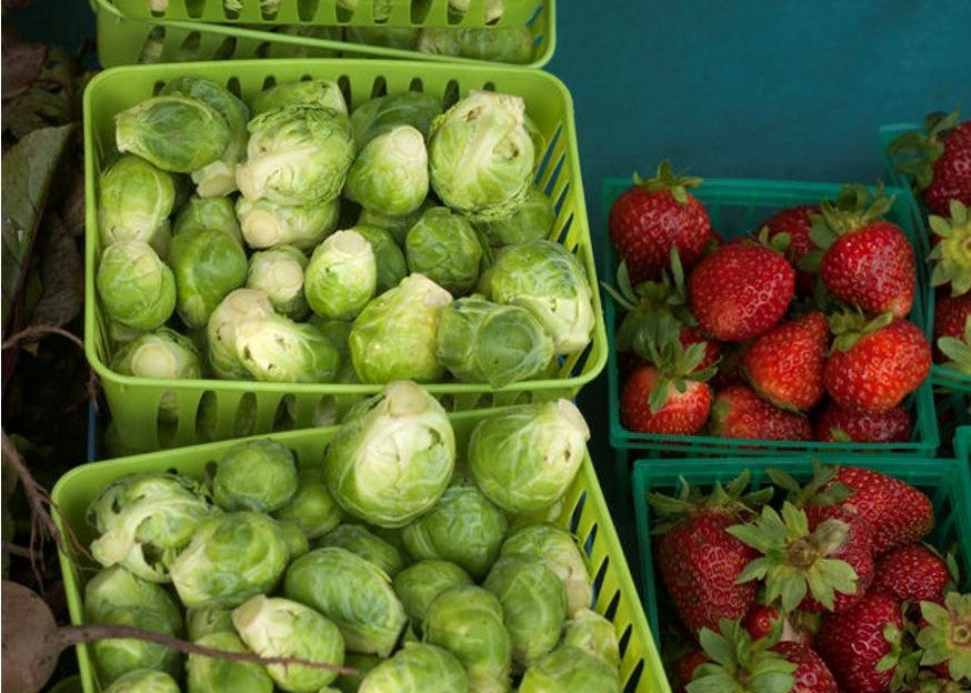 Brussels sprouts and strawberries in produce baskets