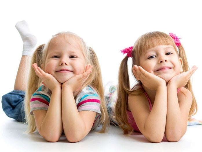 Two girls resting their hands under their chins