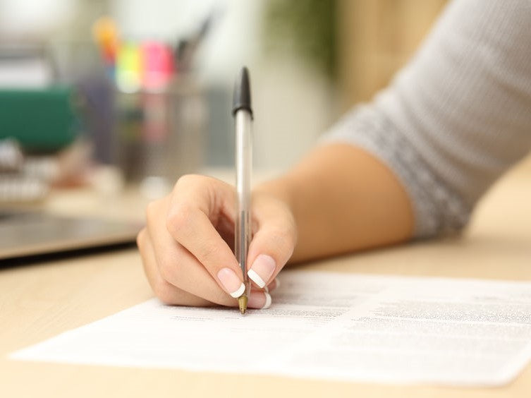 Hand completing an oral mechanism form
