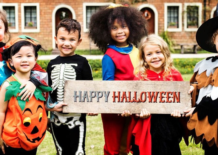 Children holding a Happy Halloween sign