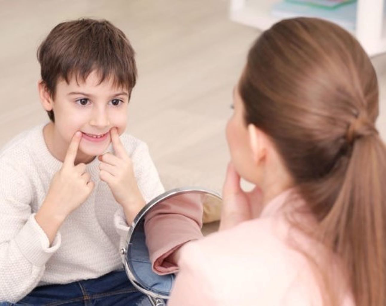 Therapist prompting a boy's mouth posture