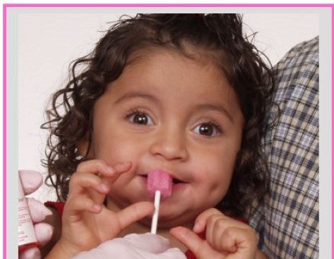 Child using a pink Toothette oral swab